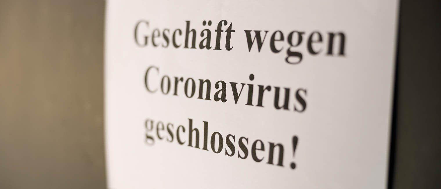Schild mit Schriftzug "Geschäft wegen Coronavirus geschlossen"